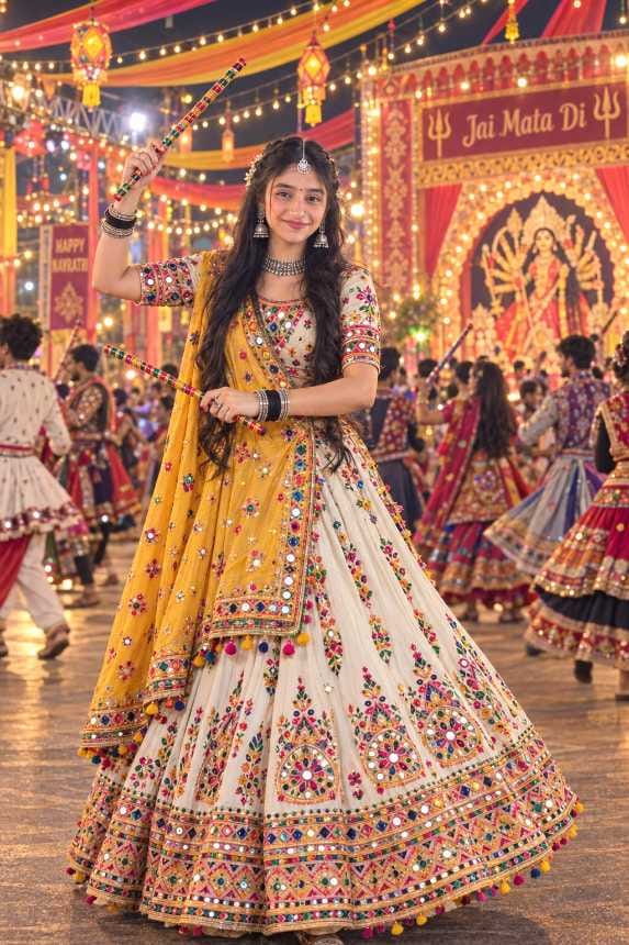 Smiling Indian girl in a white and yellow embroidered lehenga dancing garba with a dandiya stick