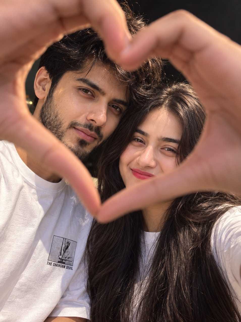 Romantic couple prompt showing a couple making a heart shape with their hands in a candid AI photo